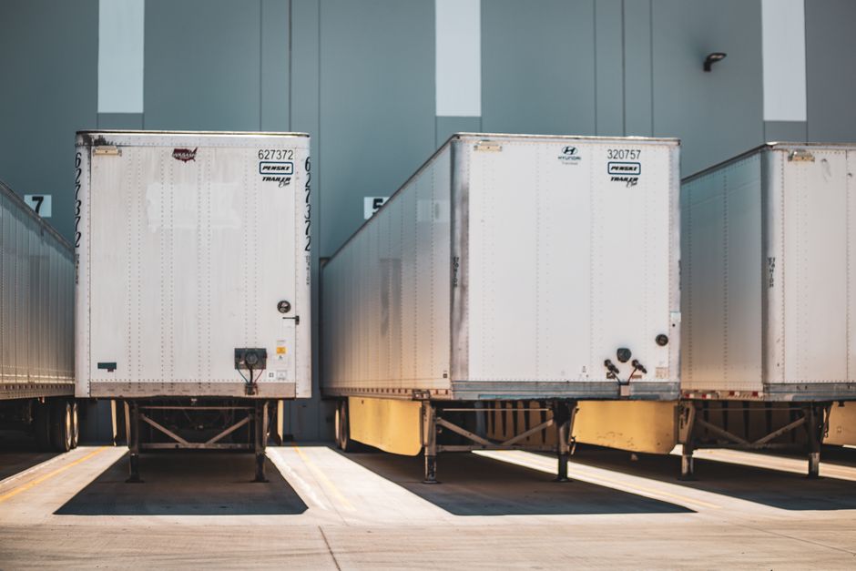 A row of freight trailers parked at a commercial loading dock, emphasizing transportation and logistics.